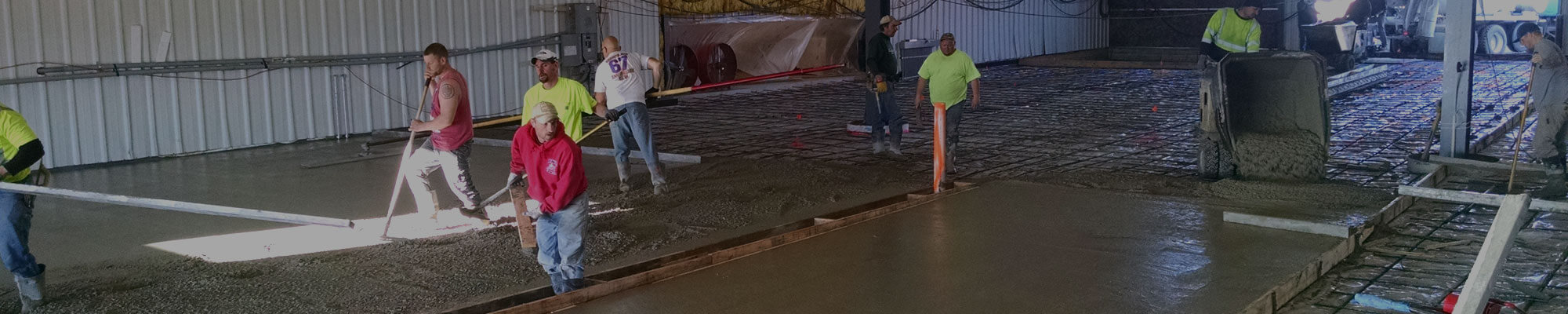 Large crew from Van Haren Construction working to pour, flatten, and smooth the concrete floor for a large commercial job